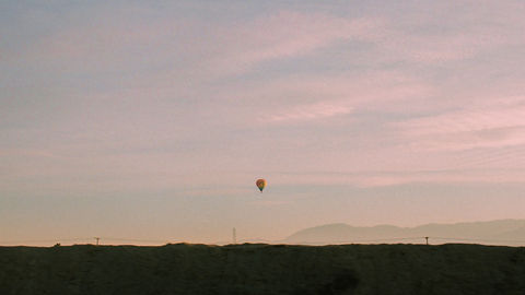 Sunset with a hot air balloon in the distance.