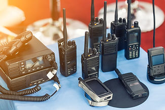 Many portable radio transceivers on table at technology exhibition. Different walkie-talki