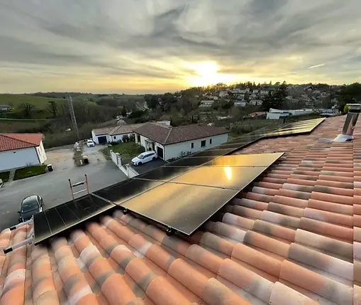 Coucher de soleil sur 21 panneaux solaires posés sur la toiture en tuile d'une maison à Montastruc