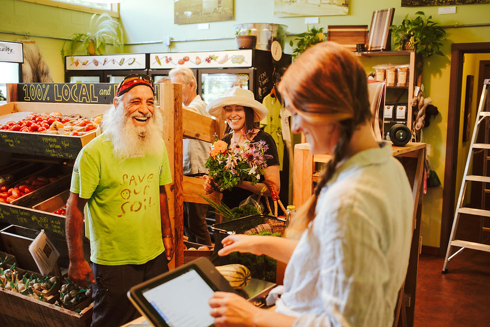 Man laughing in checkout line at local food hub.