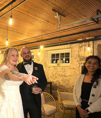 Bride and groom pointing at their live wedding painting during the reveal at their Toronto wedding at Cambium Farms