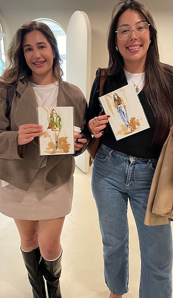 Two wedding guests smiling and holding their live guest illustrations created by Toronto live wedding artist Renu — personalized hand-drawn portraits serving as thoughtful wedding gifts and unique entertainment for guests across Ontario and Canada