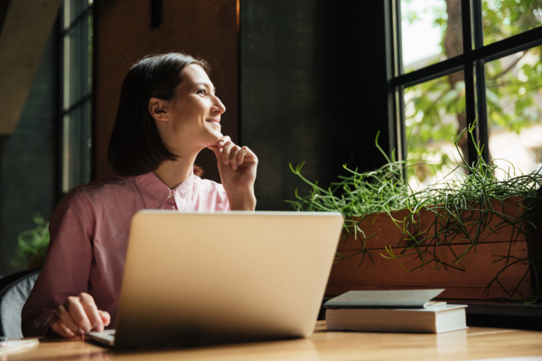 Pessoa trabalhando com laptop em café charmoso de Atibaia, aproveitando Wi‑Fi e ambiente inspirador.