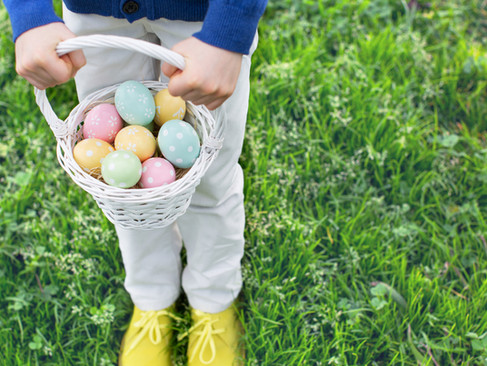 Easter Egg Hunt - A child holding a basked of easter eggs. 