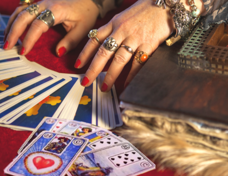 cartomante com as mãos em cima das cartas do baralho cigano