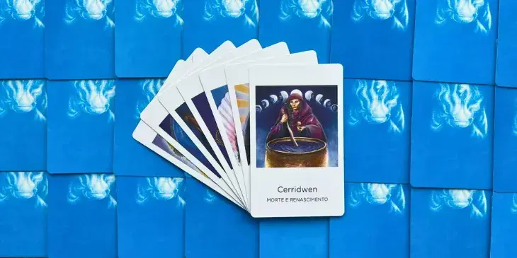 carta do oraculo da deusa carridwen é uma mulher com um caldeirao na sua frente e varias luas atrás. 