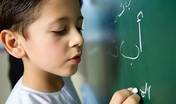 Boy Writing on a Blackboard