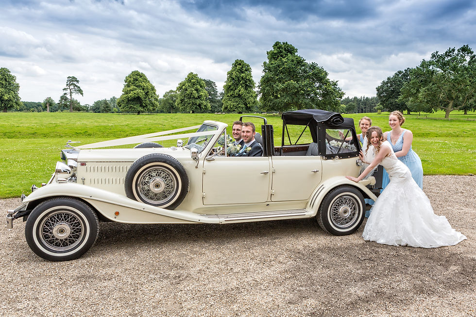 Bride and Bridesmaids pushing a vintage care with the Groom and Bestman sat inside.