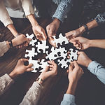 group of people holding up jigsaw pieces.jpg