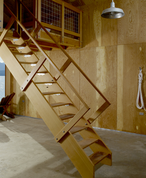 Compact loft interior with wood-paneled walls and ladder access, demonstrating efficient residential renovations.
