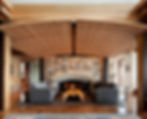 Rustic-style living room featuring vaulted ceiling with wood beams and stone fireplace.