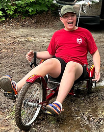 Active child with MYT1L syndrome rides his adaptive bike with joy