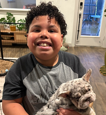 Young boy diagnosed with MYT1L syndrome looking joyful and brave, caring for his puppy