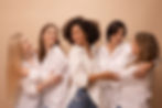 portrait-multiethnic-adults-young-women-white-shirts-hugging-each-other-brown-background.j