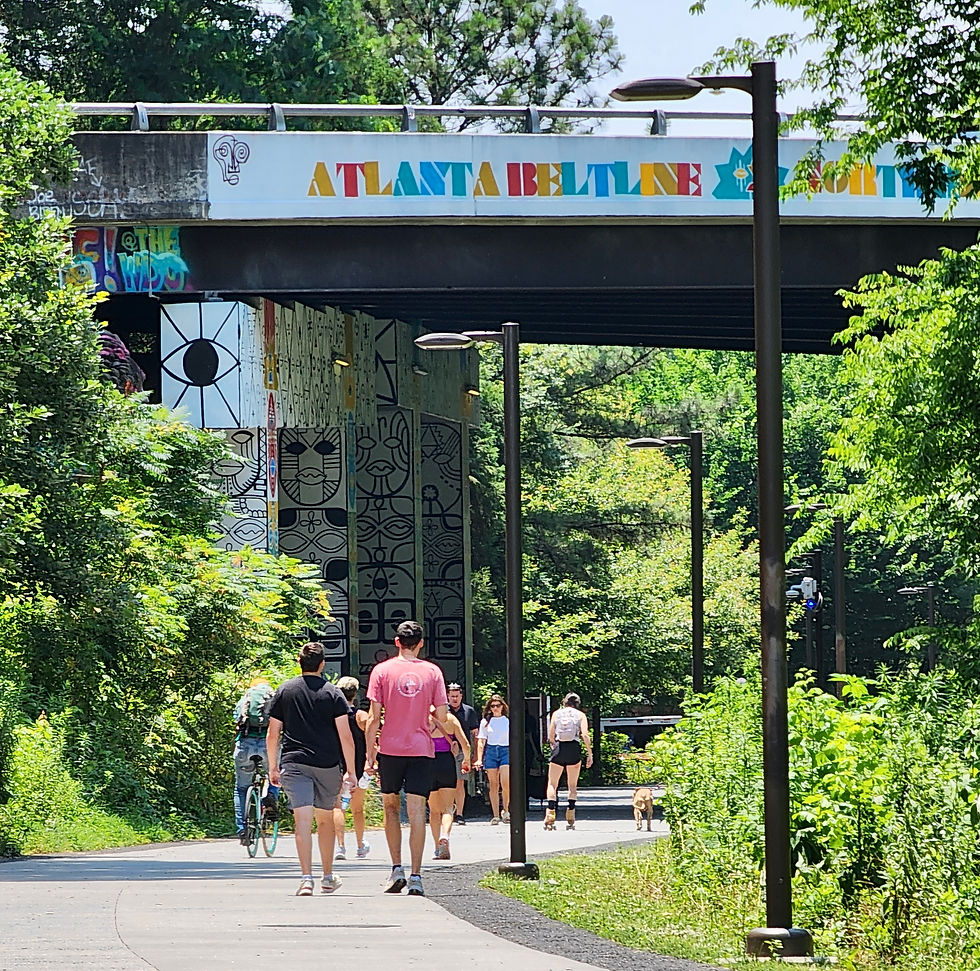 People walking on the Atlanta BeltLine with street art in the distance