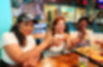 Three women toast with margaritas on a BiteLines Food and Street Art Tour