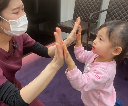 ハイタッチする子供と衛生士