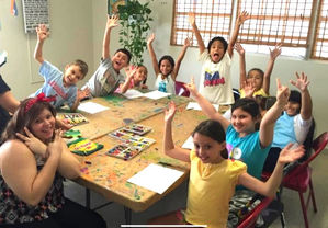 Niños y maestras divirtiéndose en el salón de arte