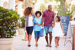 African American family shopping together at an outdoor strip mall.