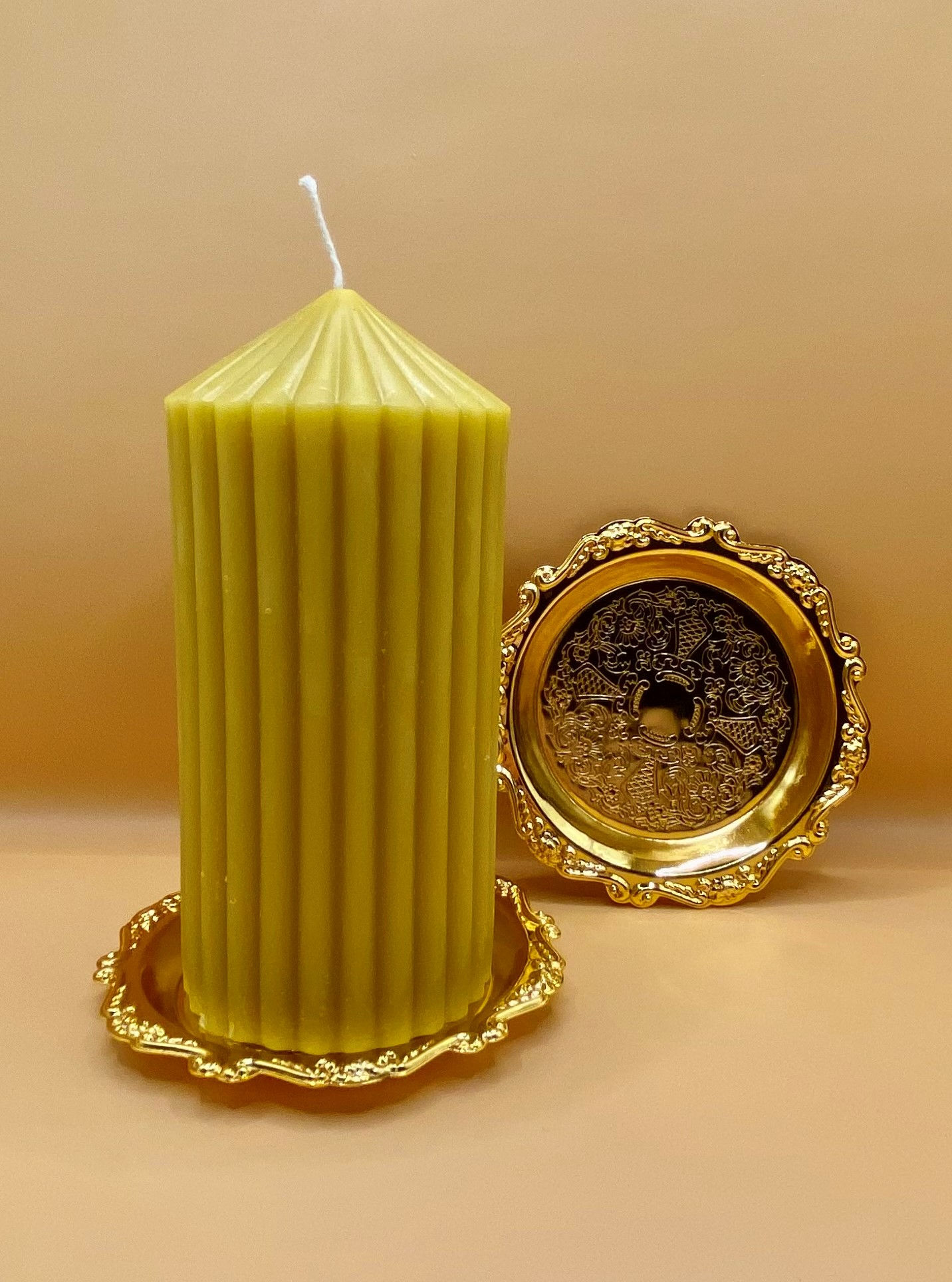 Elegant beeswax candle on gold tray