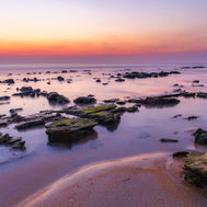 A long exposure fine art style photo of the coquina rocks and ocean during blue hour