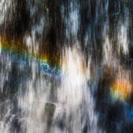 A rainbow appears in the Looking Glass Falls waterfall.