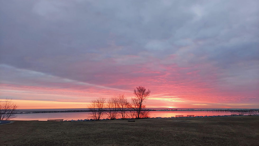 Tranquil sunrise ove a large lake with pink and blue hues.