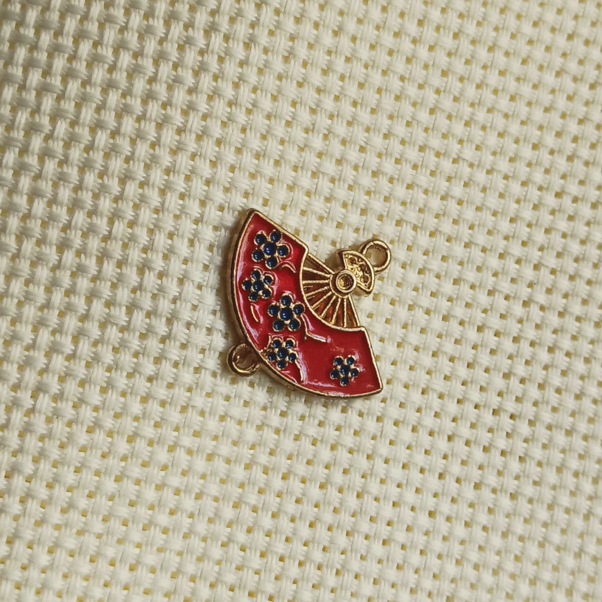 Red hand fan with floral design enamel connector charm.