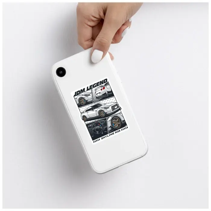 Thumbnail: Hand holding a white smartphone with the JDM car sticker applied on the back.