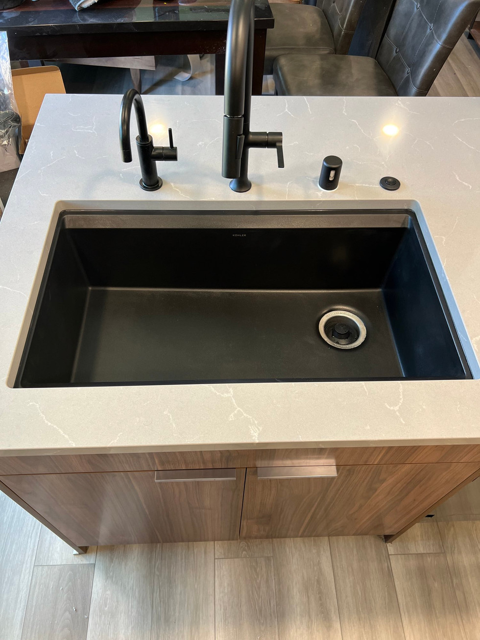 a kitchen sink with a faucet that says ' kohler ' on it