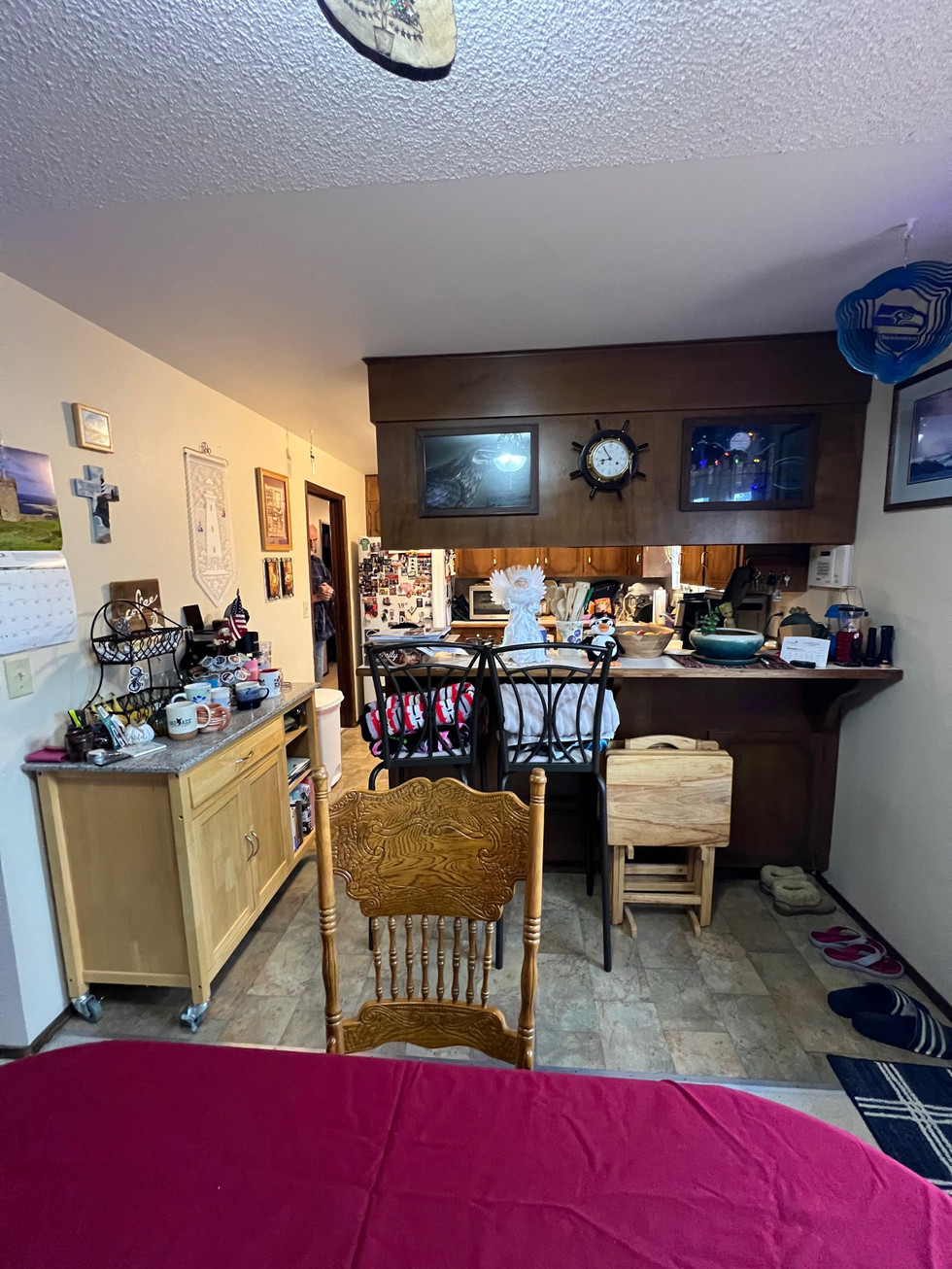 a dining room with a table and chairs and a clock on the wall