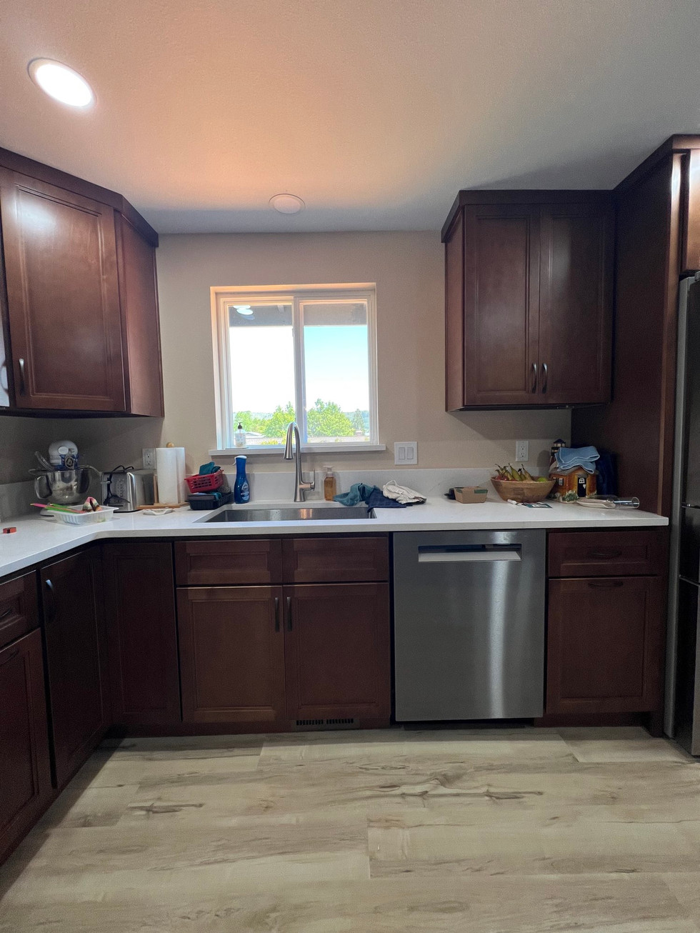 a kitchen with brown cabinets and a stainless steel dishwasher