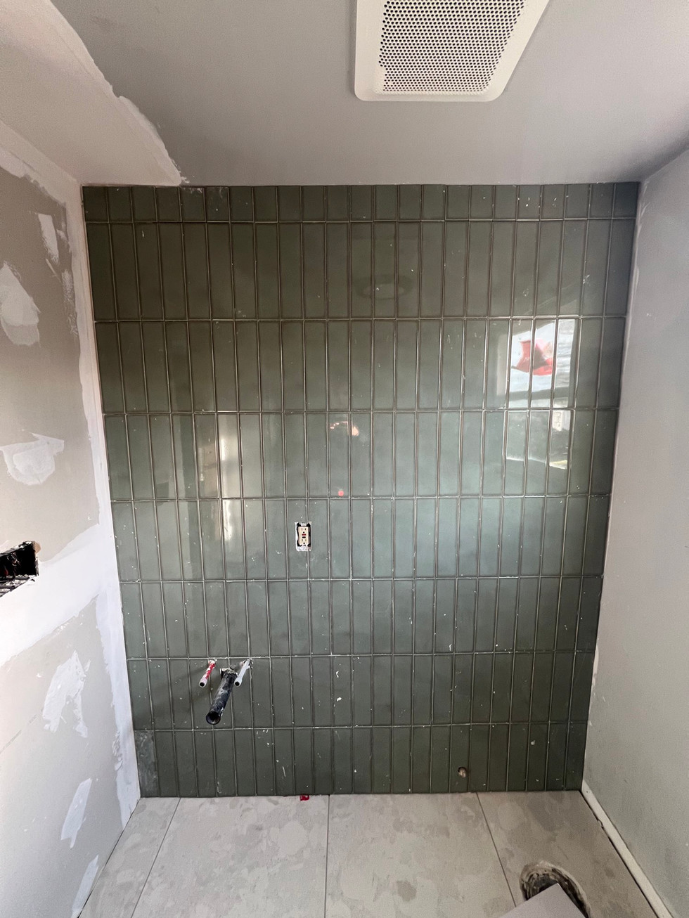 a wall with a lot of green tiles on it