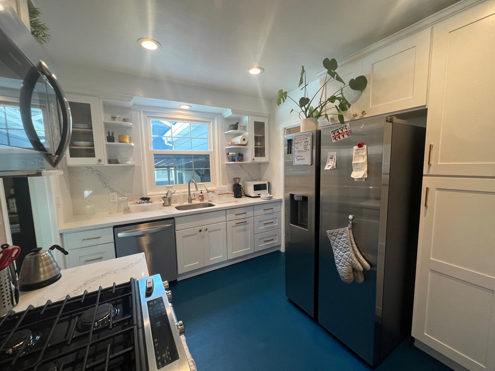 a kitchen with white cabinets and a stainless steel refrigerator