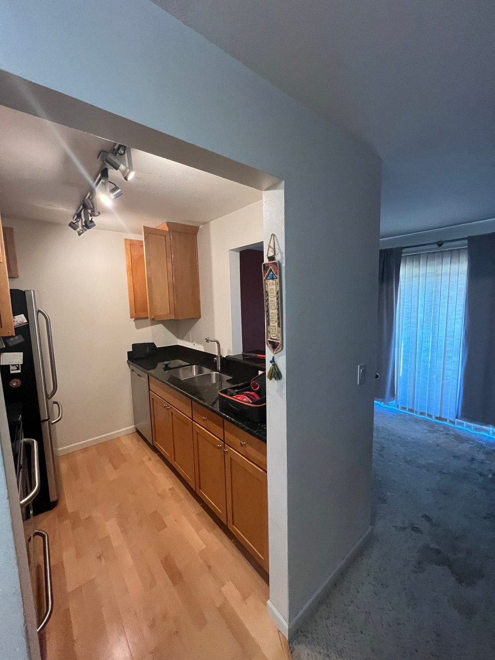 a kitchen with wooden cabinets and a black refrigerator