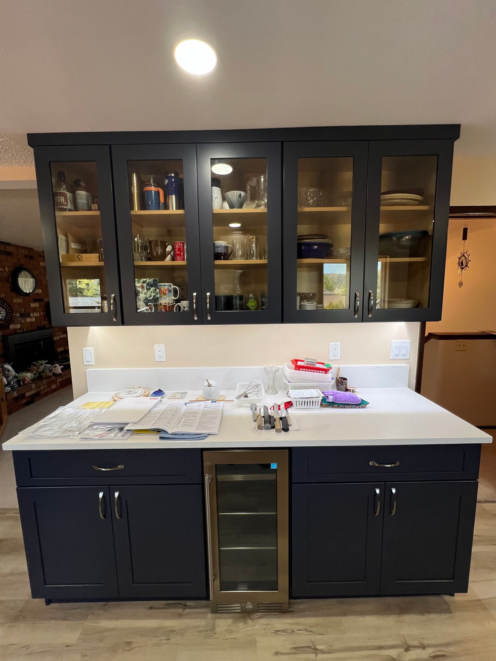 a kitchen with black cabinets and a stainless steel refrigerator