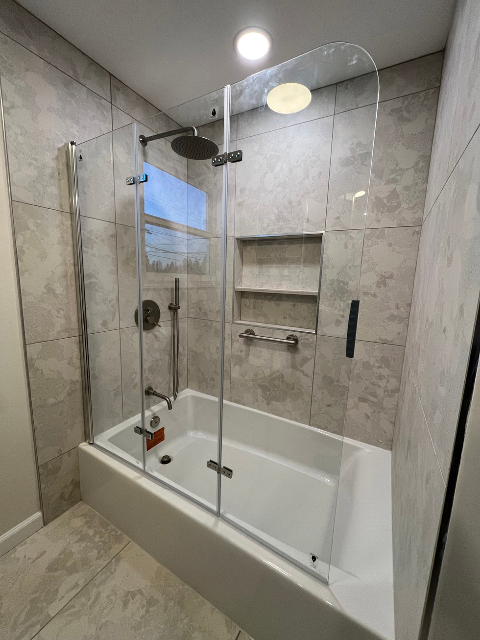 a bathroom with a bathtub and a shower with a glass door