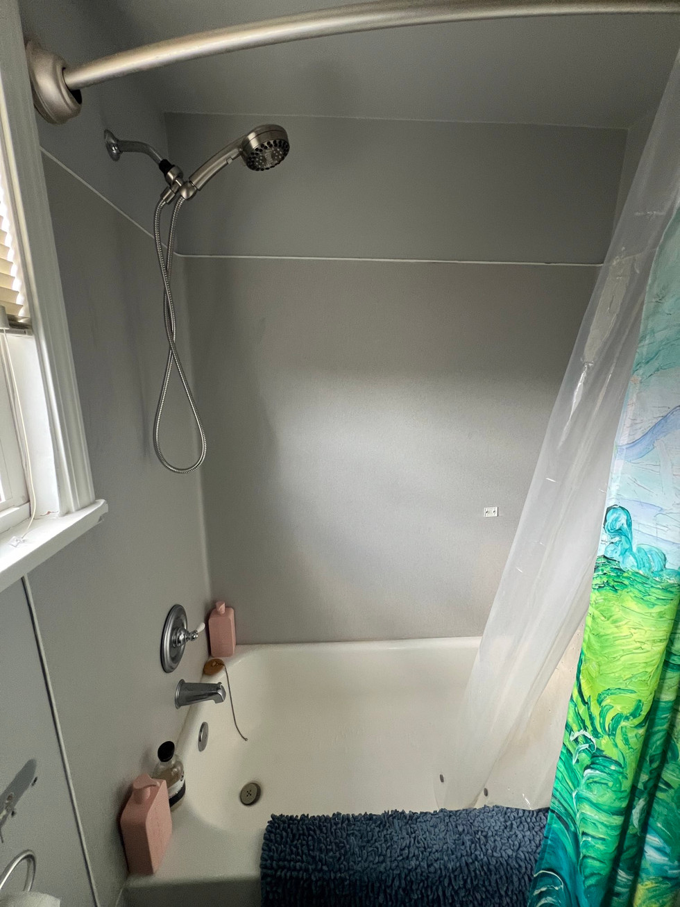 a shower with a green shower curtain and a shower head