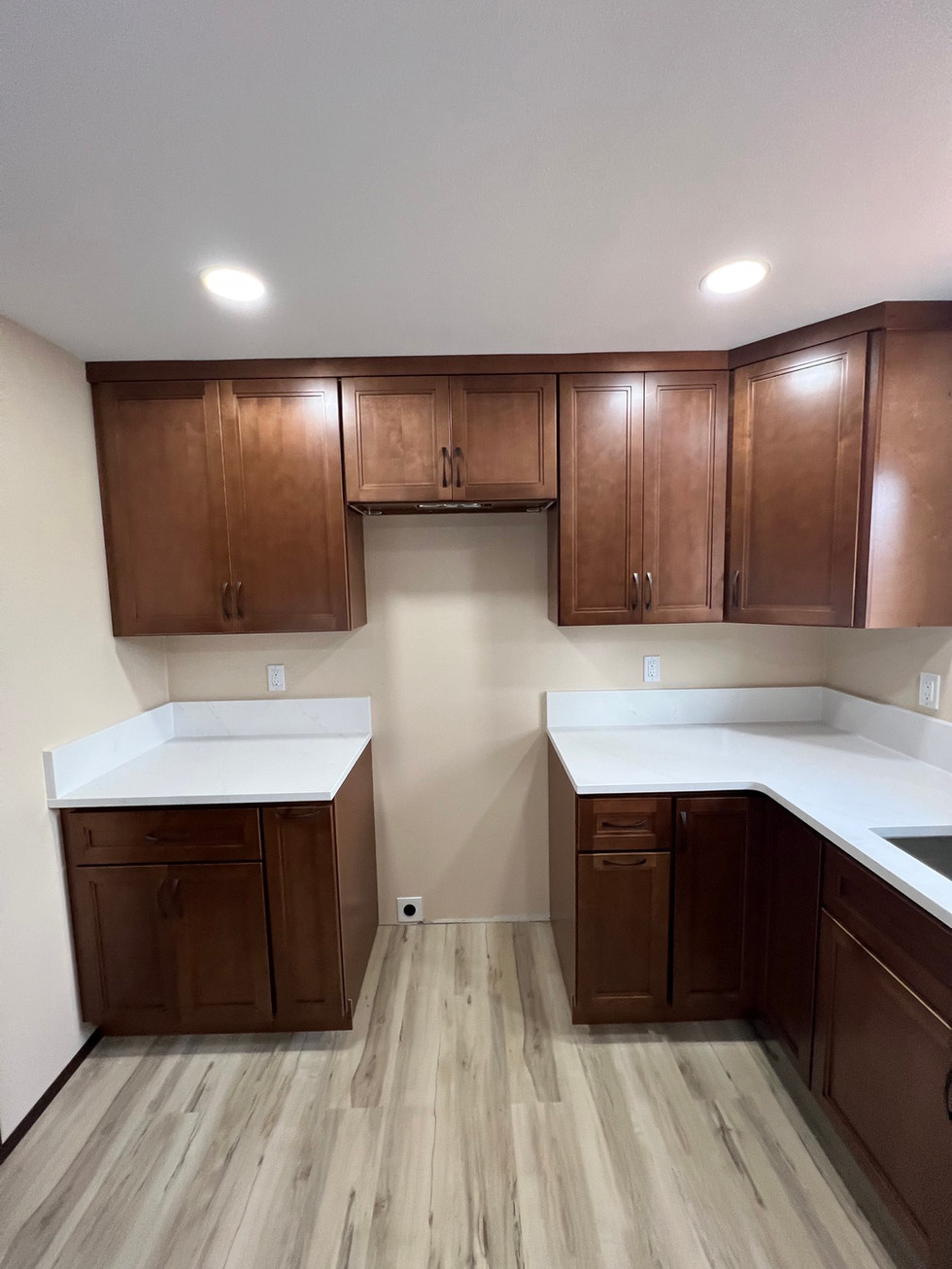 a kitchen with brown cabinets and white counter tops