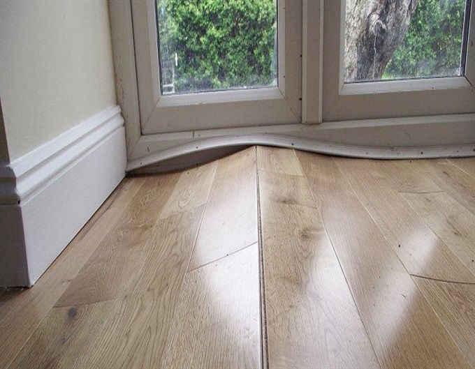 Ảnh minh họa sàn làm gỗ bị cong vênh do không khí ẩm.