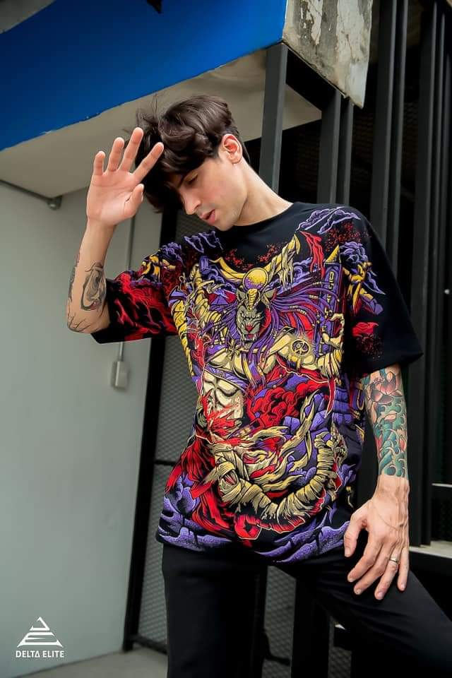 A photo of a man wearing a Delta Elite branded t-shirt with a Sekhtet design illustrated by Mad Matt Design.