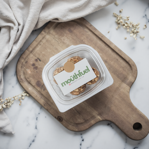 AI-created packaging mockup of a snack container, styled on a marble surface with a wooden board