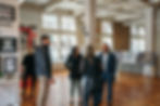 Purse Building Interiors with exposed brick and original hardwood floors and the Wildcat Management Project Team giving a tour of the rehabilitation project.