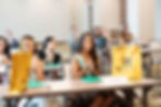 Wide angle view of diverse young women engaging in teamwork during a leadership workshop