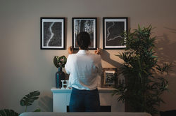 woman-arranging-paintings-home