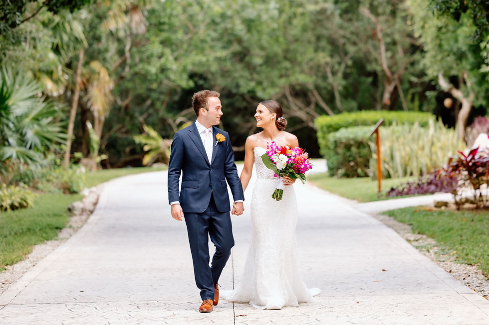 Bride and groom walking together after first look in lush Riviera Maya resort setting