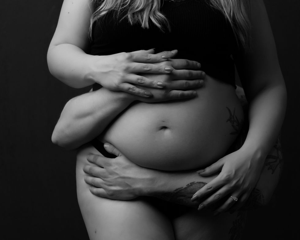 a woman with a tattoo on her stomach is being held by a man