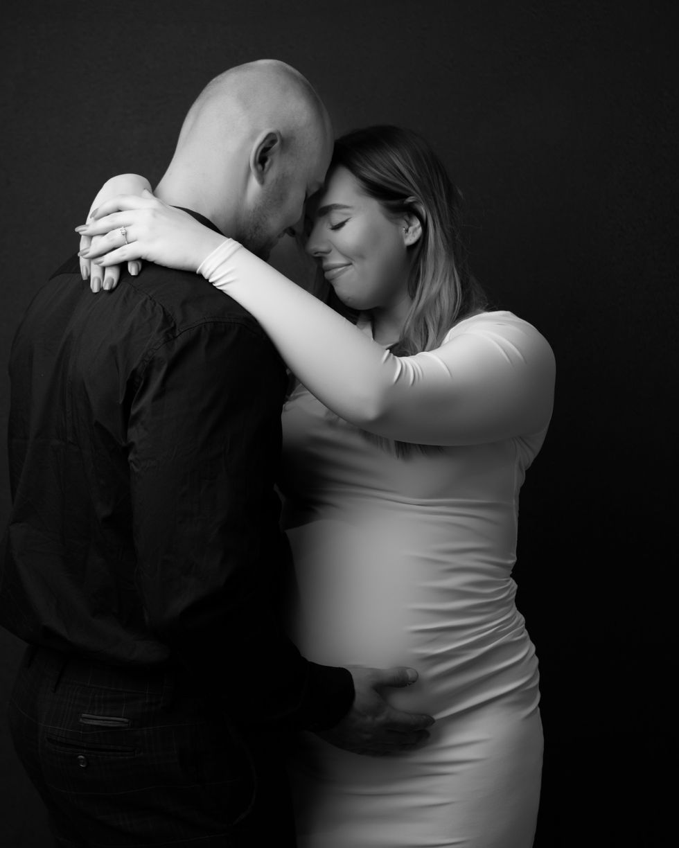 a black and white photo of a man and a pregnant woman