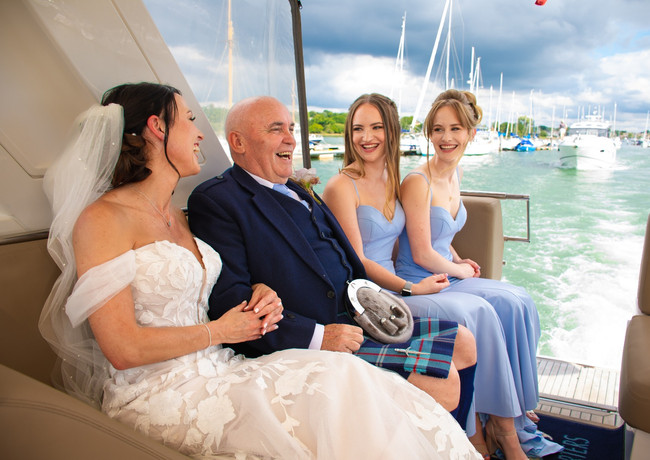 Bride, father and bridesmaids arrive to the wedding by boat at The Royal Southern Yacht Club, Hamble.