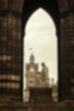 View through the Scott Monument framing The Balmoral Hotel clock tower and Edinburgh’s historic skyline in the heart of the c